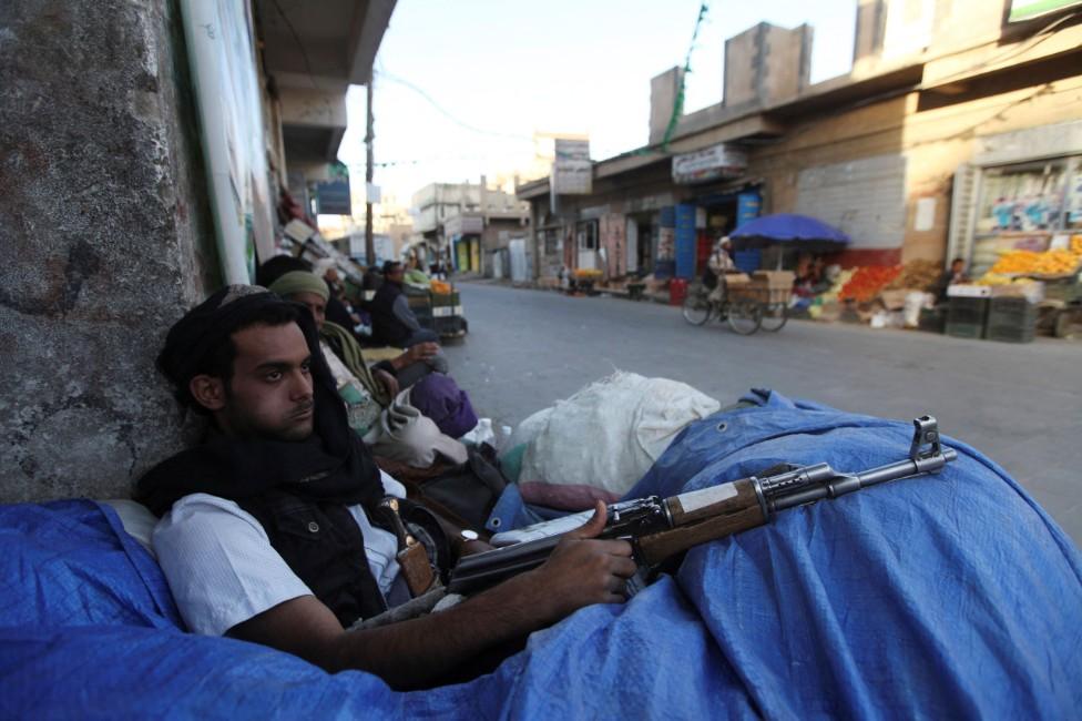 File photo of a Houthi fighter sitting behind sandbags near a checkpoint in Sanaa