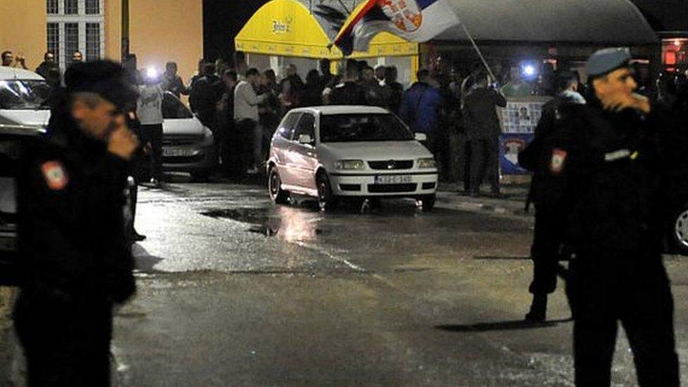 Bosnian police control streets while a group of Bosnian Serbs wave Serbia's national flag as they gather in the centre of the eastern Bosnian town of Srebrenica, in the early hours on October 3, 2016