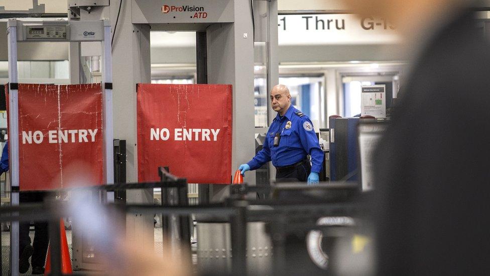 A TSA officer closes the entrance of the Miami International Airport's Terminal G, during the government shutdown, in Miami, Florida, 12 January 2019