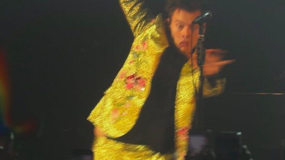 Screengrab from video of Harry Styles performing Kiwi and slipping on a kiwi