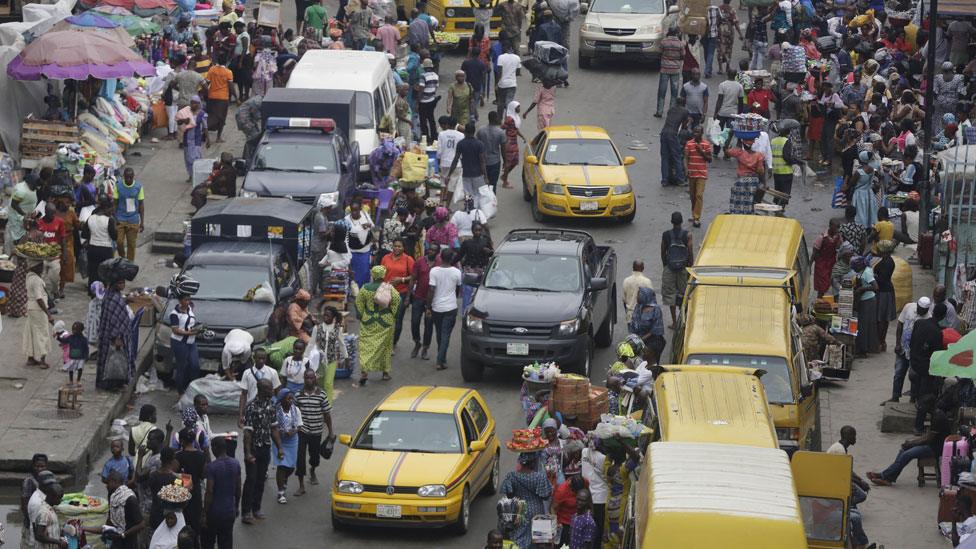 Pedestrians shop at a market in Lagos, Nigeria on 20 June 2016