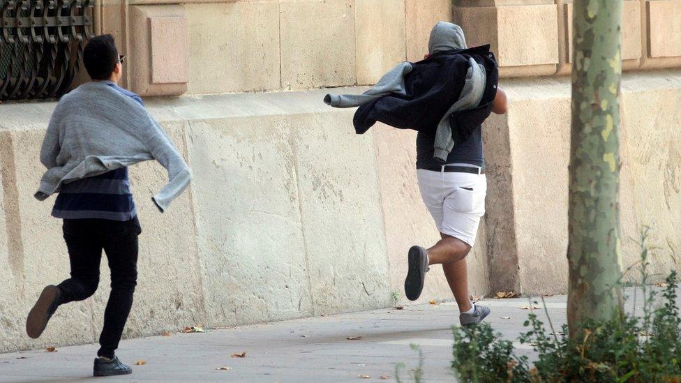 Defendants run from the court in Barcelona, 3 July