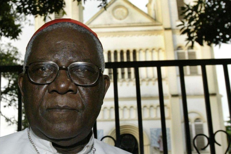 Christian Tumi poses in front of his diocese in Douala in 2004