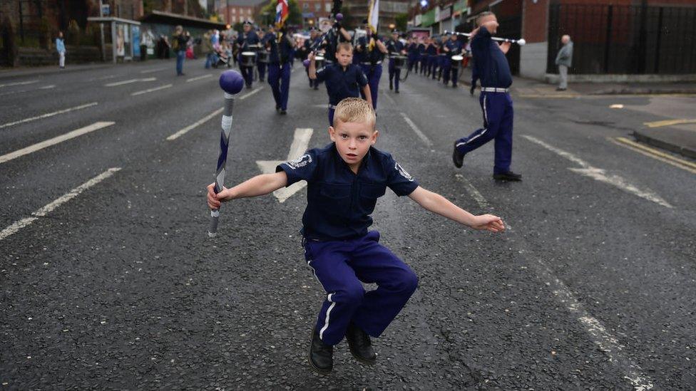 A young band member catches his baton as an Orange band makes it's way along the parade route during the Twelfth of July March