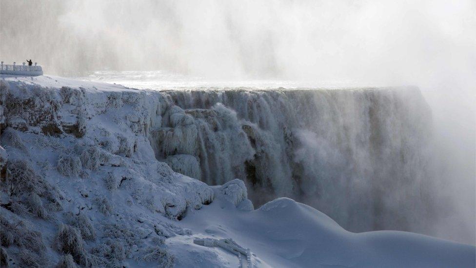 A person takes a selfie beside on the US side of Niagara Falls as seen from Niagara Falls, Ontario, Canada on January 31, 2019