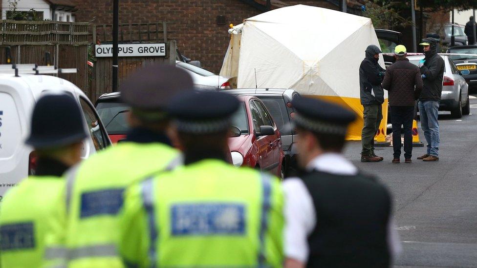 Officers work at the scene where a man was shot by police