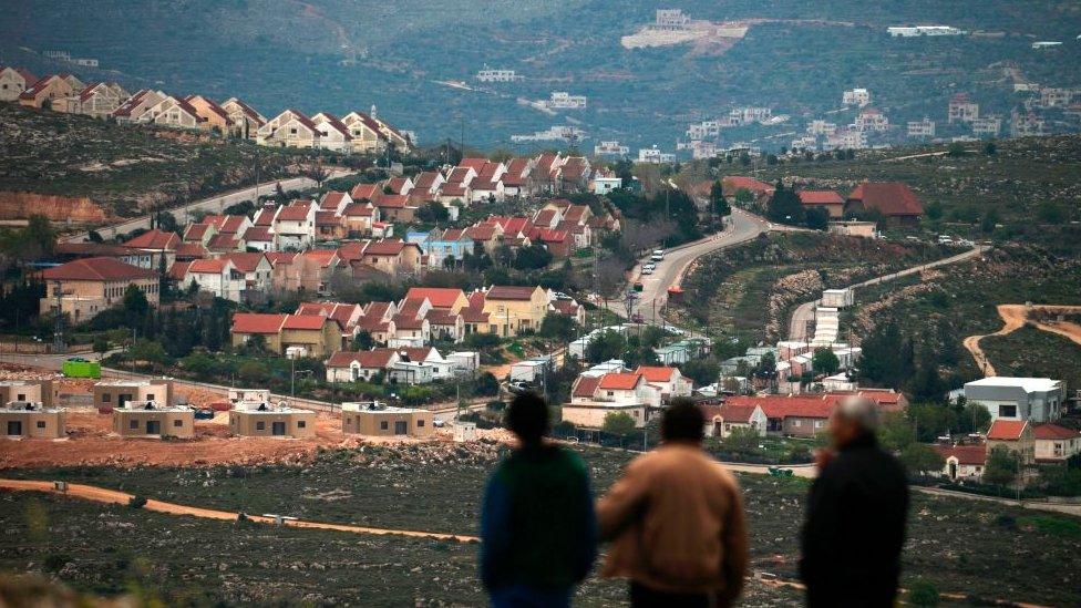 People stand in front of the Jewish settlement of Shvut Rachel during a tour organised by the Palestinian authorities for ambassadors based in Tel Aviv and consuls based in Jerusalem on March 16, 2017