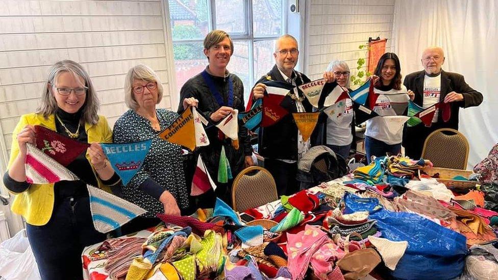 People from Beccles and Petit-Couronne holding up bunting