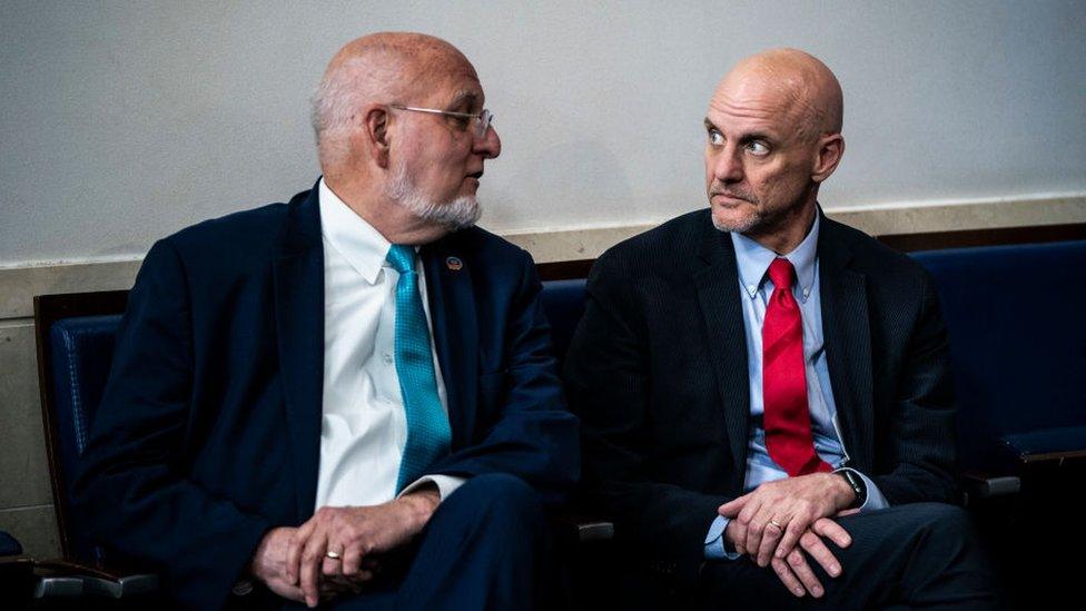 Dr Robert Redfield and Stephen Hahn talking to each other on a bench