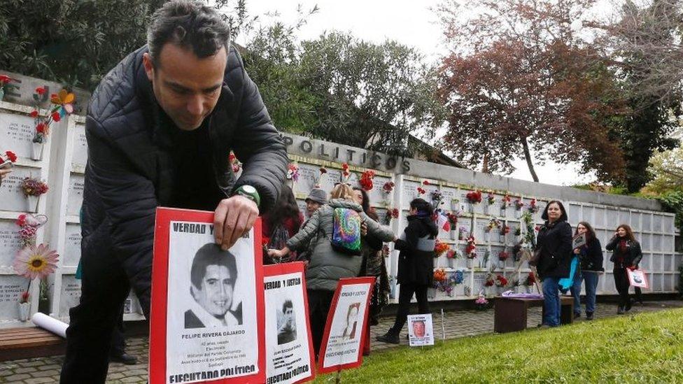 A man places a poster of a person who went missing during former General Augusto Pinochet's regime, that reads "Political executed", during a rally marking the anniversary of the 1973 military coup in Santiago, Chile September 10, 2017