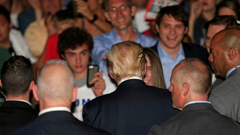 Flanked by members of the Secret Service, Republican presidential candidate Donald Trump