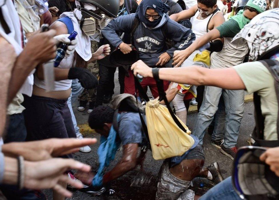 Opposition demonstrators pour petrol over an alleged thief during a protest against the government of President Nicolas Maduro in Caracas on May 20, 2017