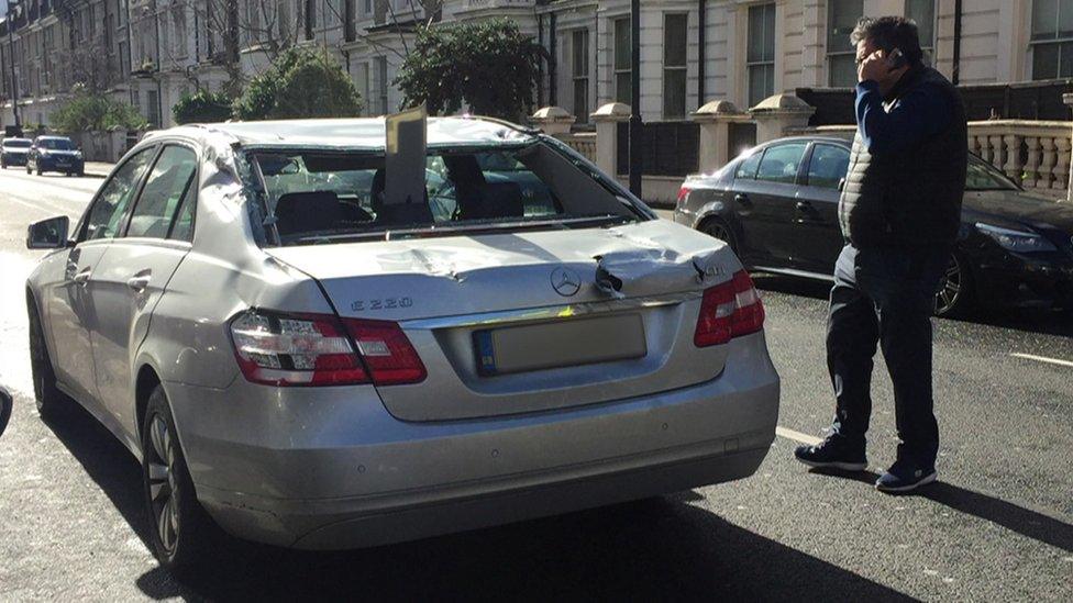 Car with plank of wood through back window