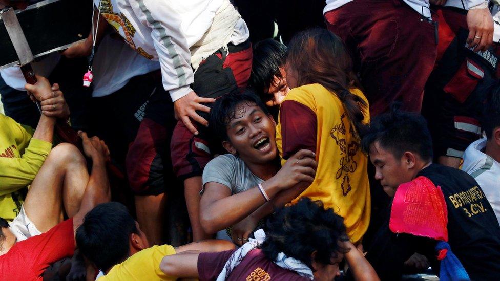 A man's face is seen among a pile of people in Manila, Philippines (9 Jan 2019)