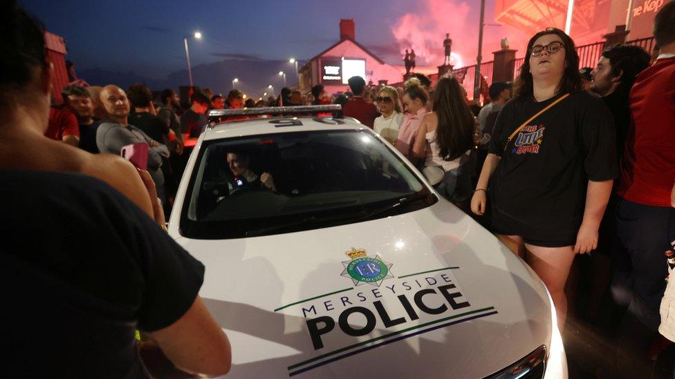 Police car cuts through crowd outside Anfield