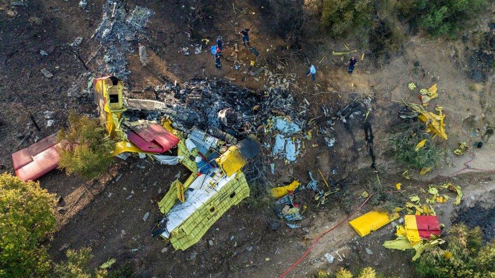 Rescuers operate at the site where a firefighting plane crashed after a water drop as a wildfire burns in Karystos on the island of Evia, Greece, July 25, 2023.