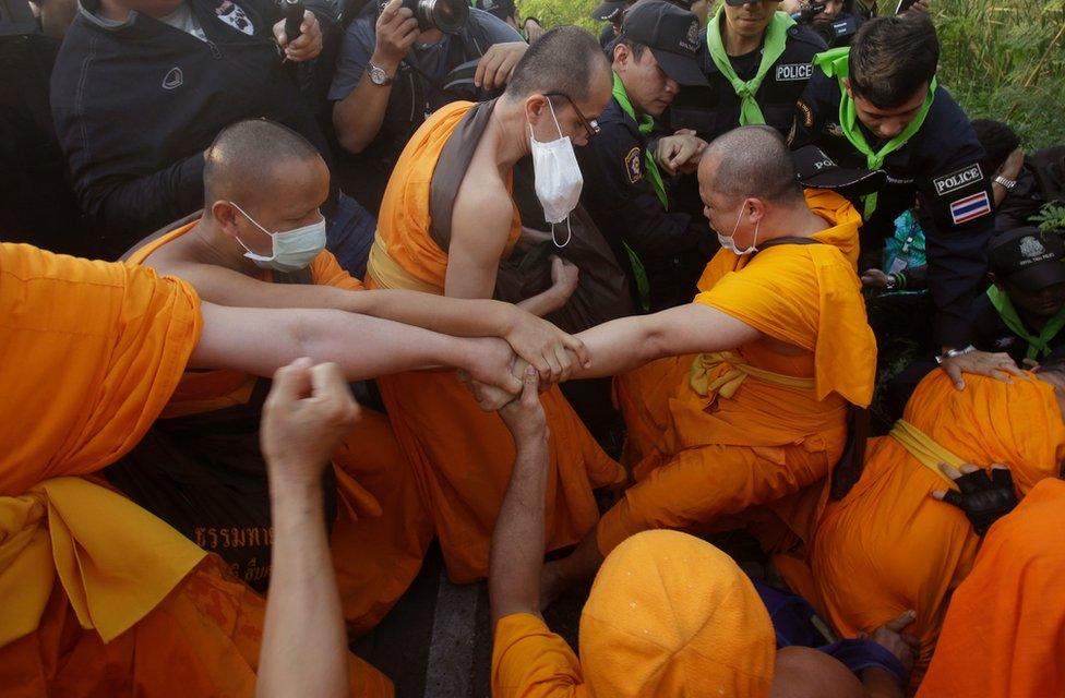 Buddhist monks of the Dhammakaya sect temple pull their felllow monk as they scuffle with Thai policemen outside the temple in Pathum Thani, north of Bangkok, Thailand, Monday, 20 February 2017.