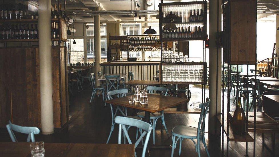 Image showing empty chairs and tables in a restaurant in London.