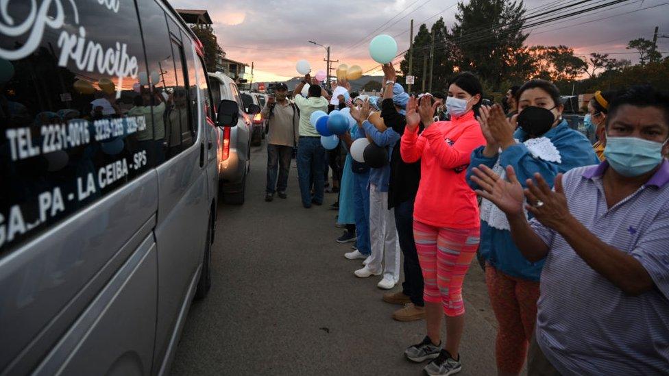 People applaud as the hearse carrying the coffin of Nurse Keyla Martinez's pass by during her funeral in La Esperanza, Honduras, on February 9, 2021.