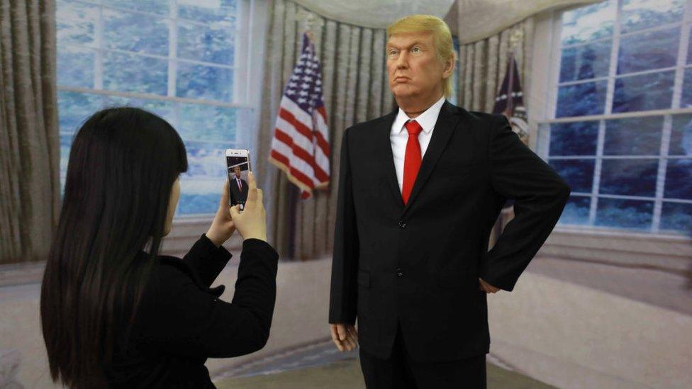 A Chinese visitor taking a photo of a wax figure of US President Donald Trump in Shenyang, northeastern China's Liaoning province