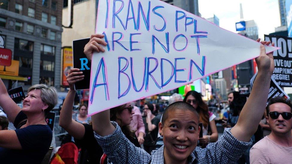 Protesters display placards against Donald Trump during a demonstration in front of the US Army career centre in Times Square, New York