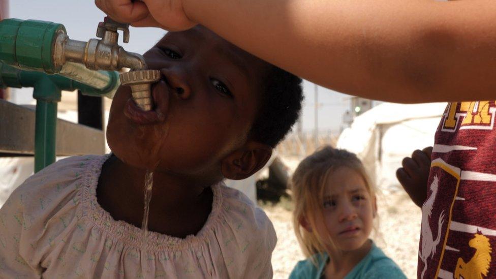 Child drinking from a water tap