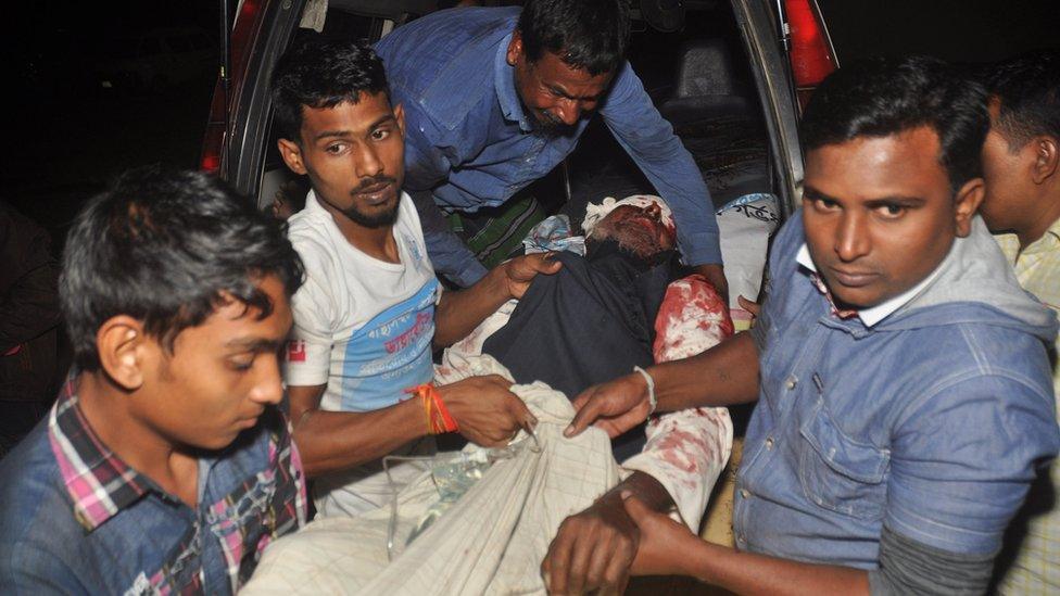 A man injured in an attack on a Shia mosque is carried for treatment in Bogra, Bangladesh