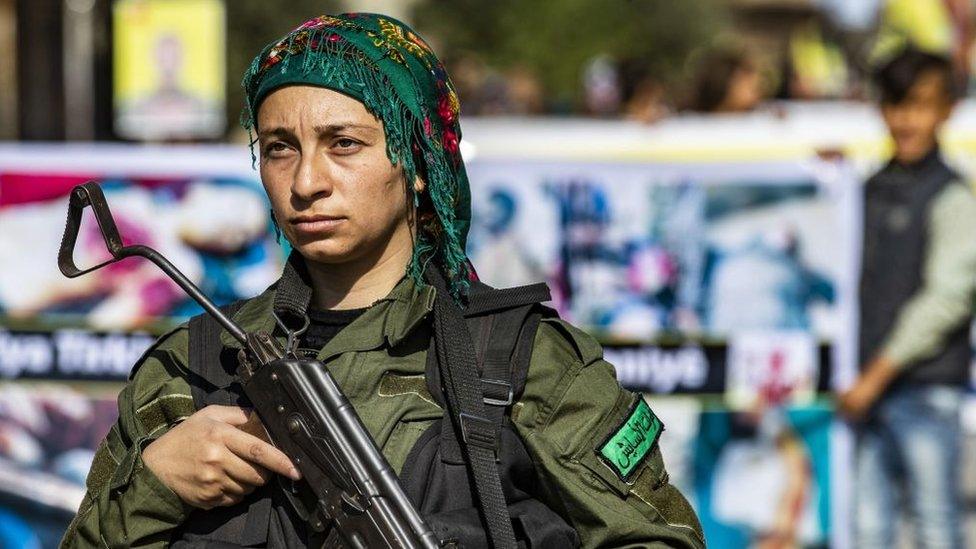 A member of the Kurdish Internal Security Force stands guard during a protest against the Turkish assault on north-eastern Syria