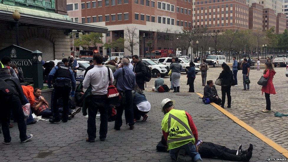 Commuters, some injured, and rescue personnel are pictured outside Hoboken station on 29 September 2016