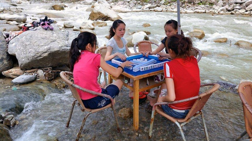 Mahjong players in a river