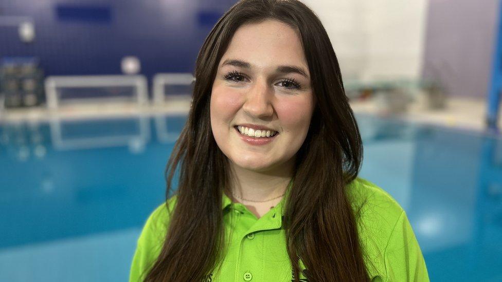 Marianne Baker smiling as she stands in front of a swimming pool