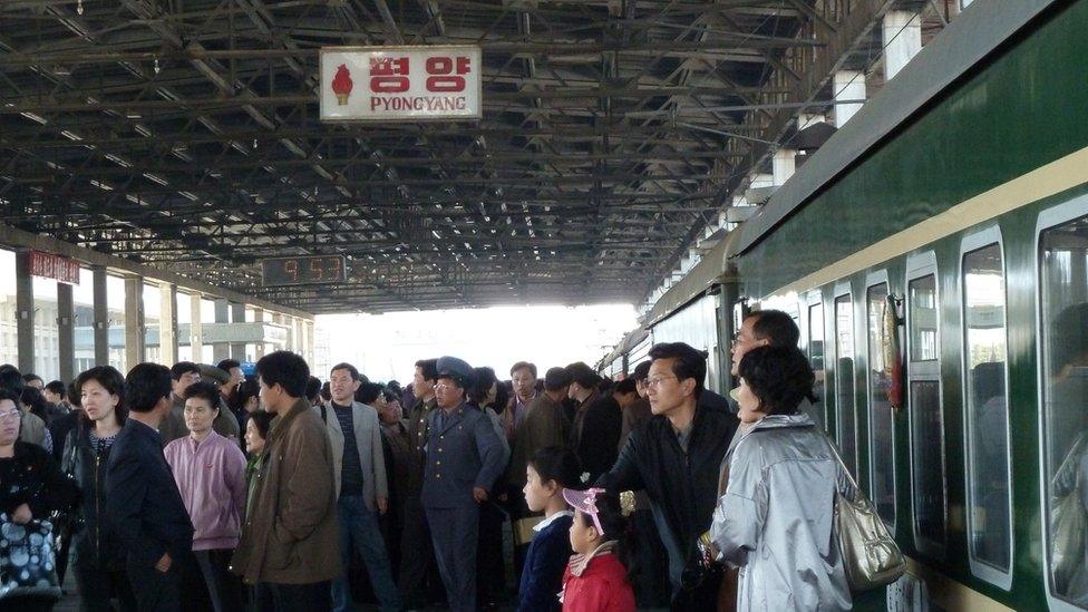 Passengers crowd the platform at the Pyongyang Railway Station as a train prepares to depart for Beijing