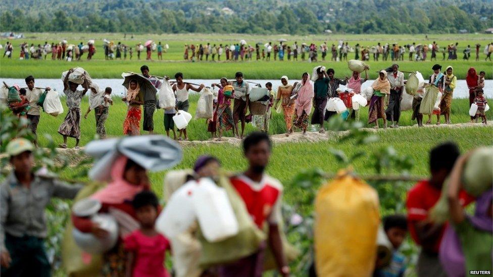 Rohingya refugees walk after they received permission from the Bangladeshi army to continue on to the refugee camps