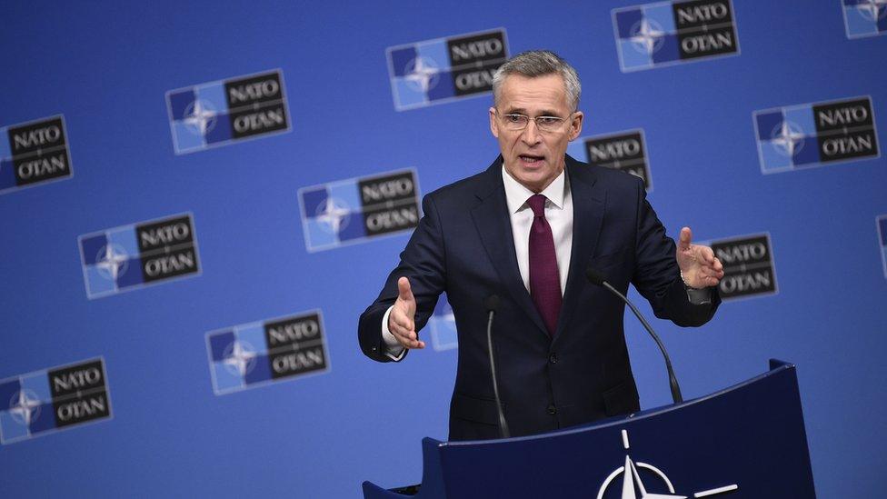 Jens Stoltenberg standing at a podium giving a speech