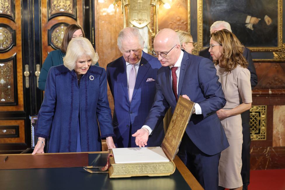 The First Mayor of Hamburg Dr. Peter Tschentscher show King Charles III and the Queen Consort the Golden Book in the Emperor's Hall during a visit to Hamburg City Hall (Rathaus), the seat of the Hamburg government, on the final day of their State Visit to Germany