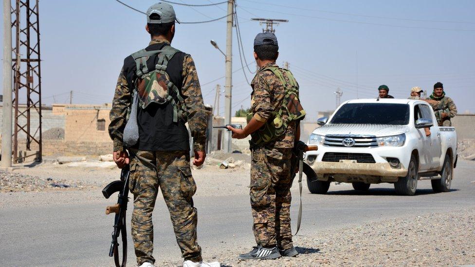 Syrian Democratic Forces fighters stand guard on the outskirts of Raqqa, Syria (11 June 2017)