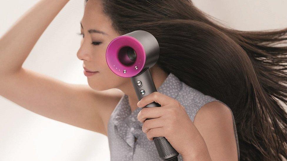 A woman using Dyson hairdryer