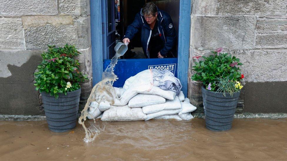 Someone with sandbags on flooded path