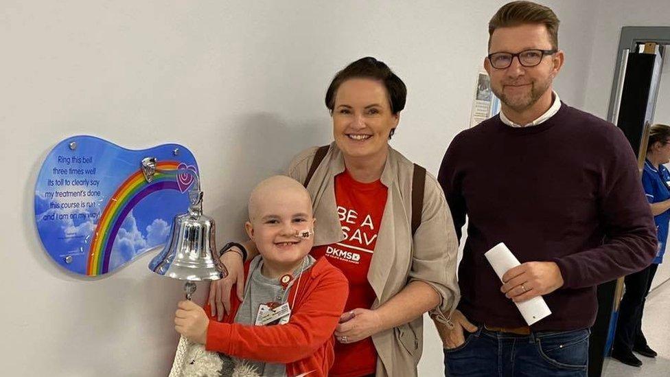 Finley ringing the bell with his parents