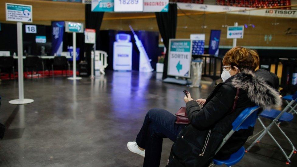 A woman waits to be vaccinated at the indoor Velodrome National of Saint-Quentin-en-Yvelines in Montigny-le-Bretonneux, southwest of Paris