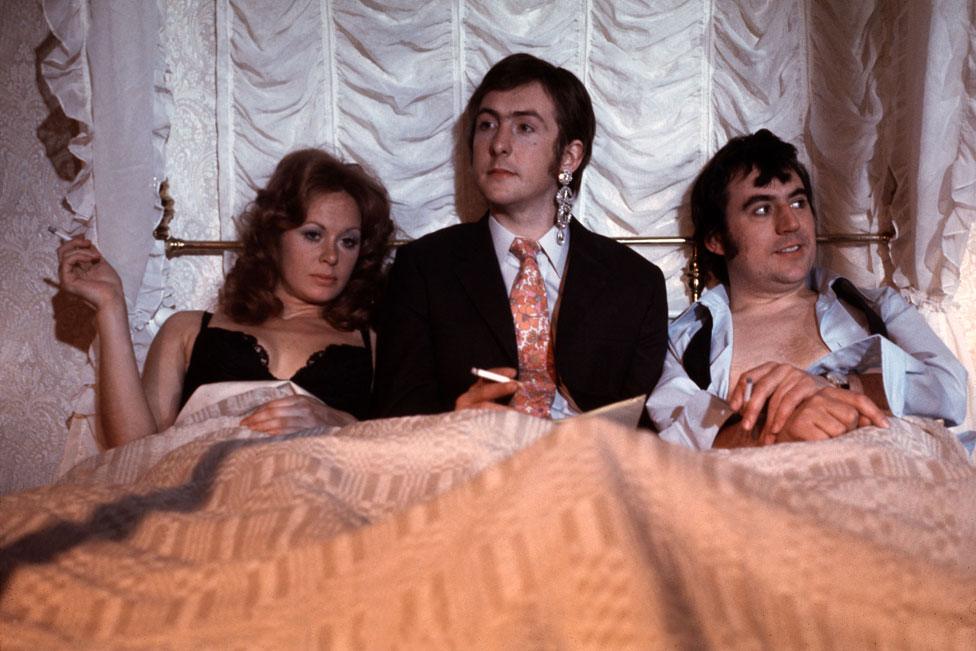 Carol Cleveland as Dora, Eric Idle as the newsreader, and Terry Jones as Bevis in the sketch Newsreader Arrested/Romantic Film. This sketch was originally used in Monty Pythons Flying Circus Series one.