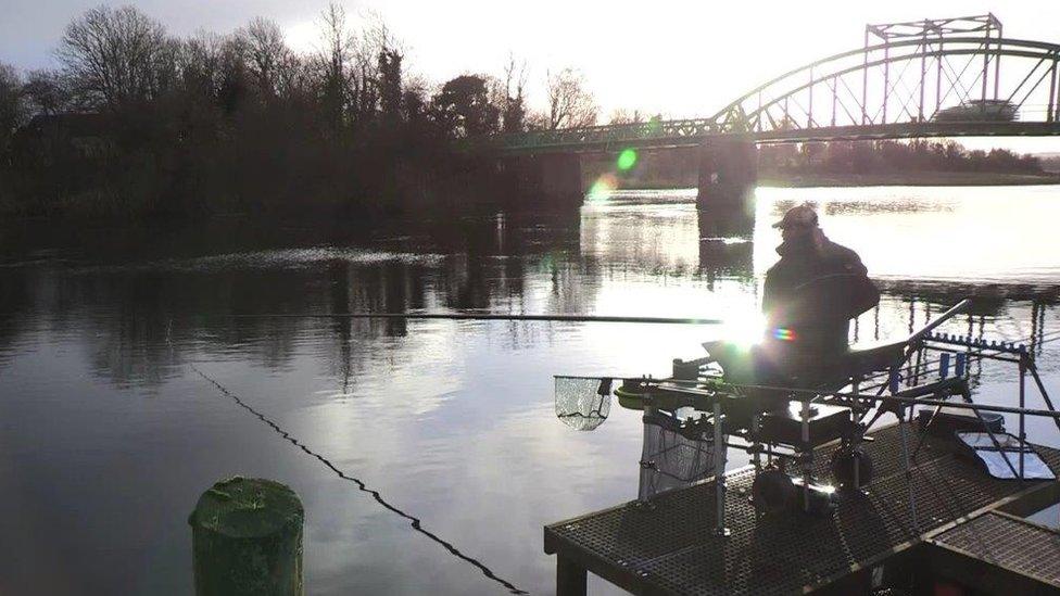 A fisherman waits patiently on his catch at Lough Erne