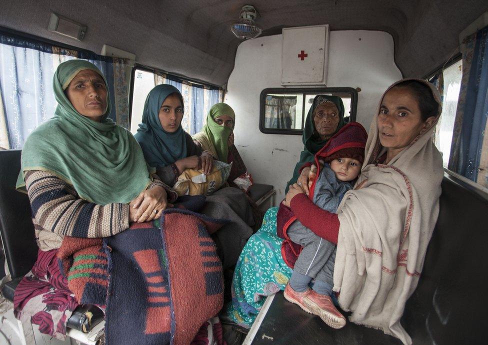 Women and children being evacuated in an ambulance.