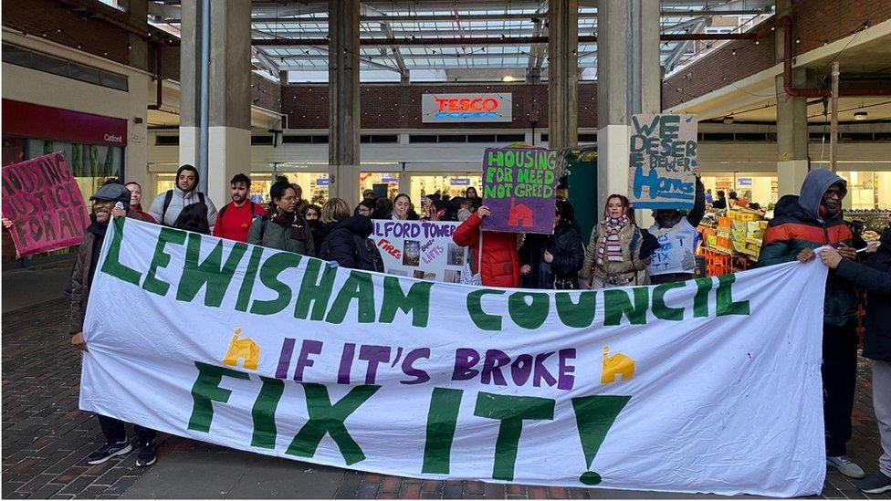 Protesters holding placards and a banner