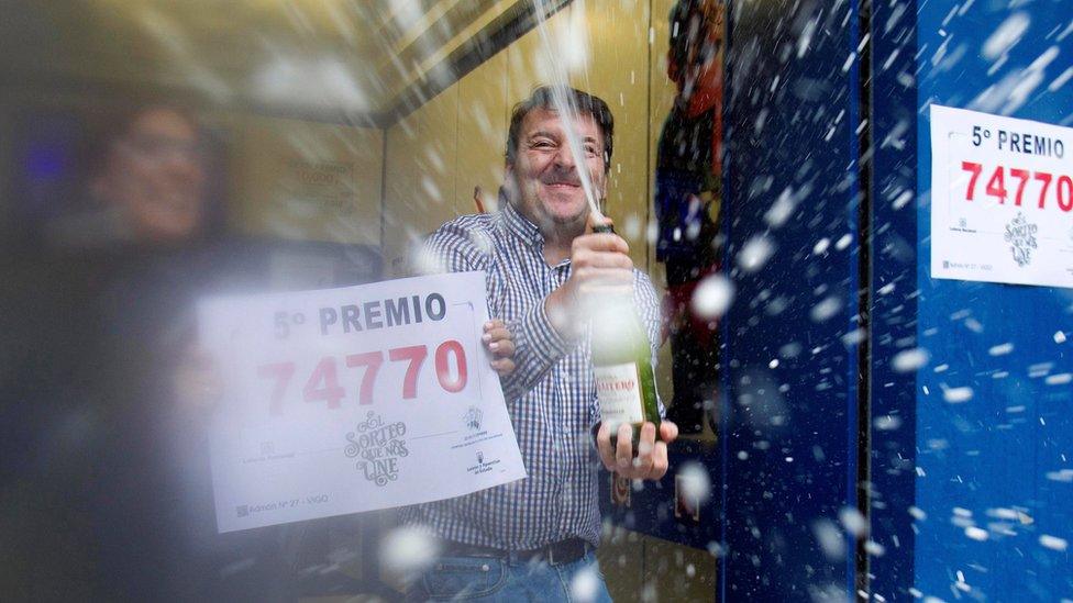 People celebrate selling the number 74770, winner of one of the eight 5th prizes of "El Gordo".