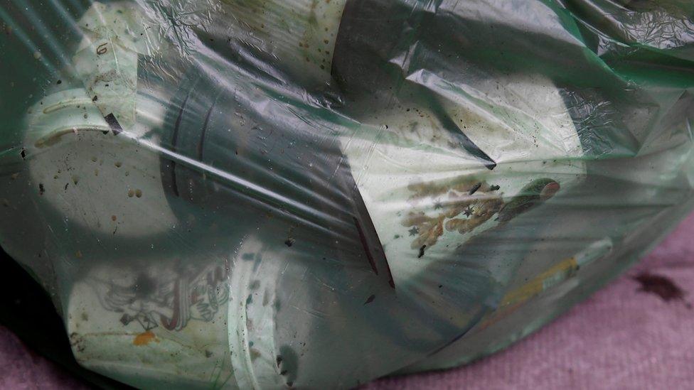 Disposable coffee cups are seen in a refuse bag in London,