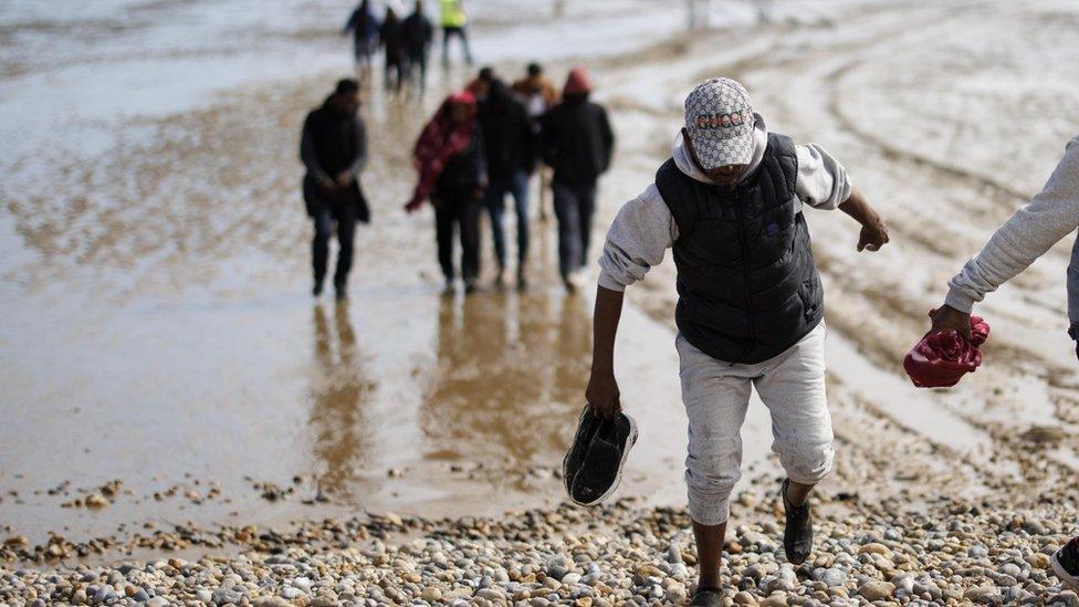 Migrants rescued from a boat crossing the English Channel land on Dungeness Beach in Kent, Britain