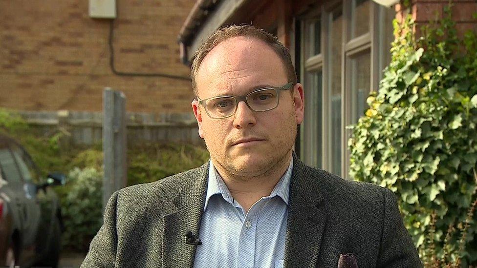 Dr Jamie Green with short brown hair standing in a garden