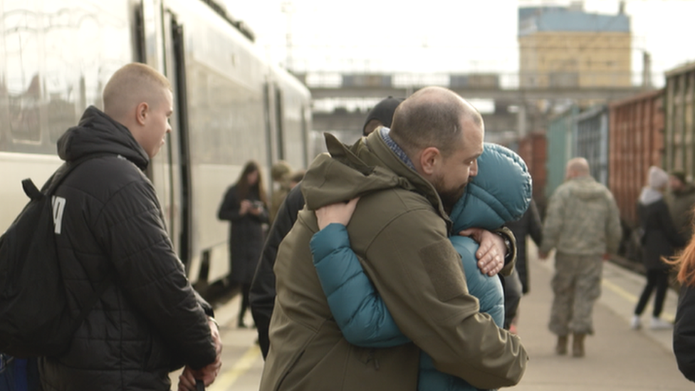 Two people hug at Kramatorsk train station