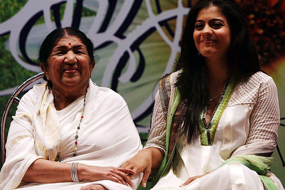 Lata Mangeshkar receives an award in the company of actress Kajol Devgan in Mumbai on April 24, 2010